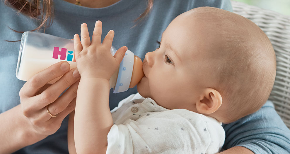 A baby is drinking from a bottle.