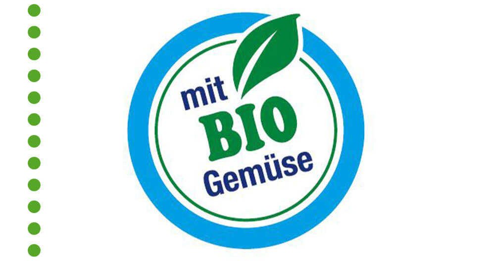 A circular blue and white logo featuring a green leaf and the German text ‘mit BIO Gemüse’ (‘with organic vegetables’) inside.