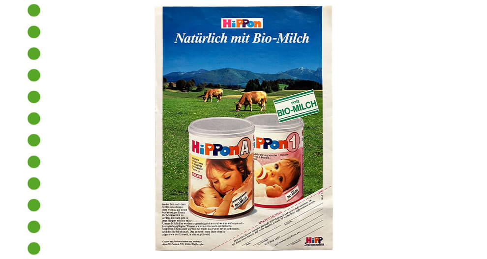 Eine Produktwerbung für "HiPPon"-Babynahrung mit einem malerischen Hintergrund einer grünen Wiese und grasenden Kühen, die die Verwendung von "BIO-MILCH" hervorheben.