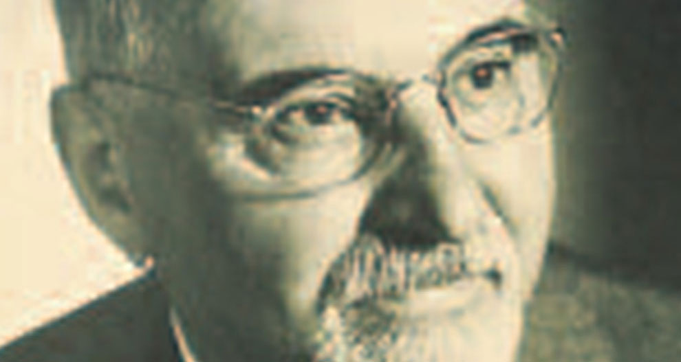 Gros plan du visage d'un homme, montrant ses yeux, son nez et sa bouche, avec une barbe et une moustache, portant des lunettes.