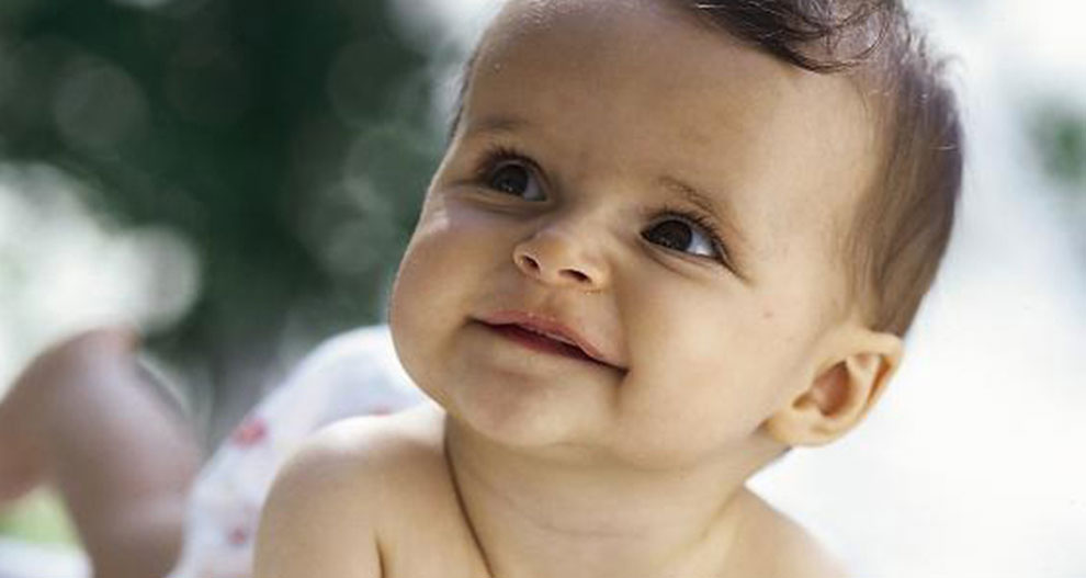 Un bébé à l'expression curieuse regarde vers le haut.