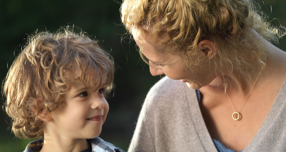 Une femme et un jeune garçon vivent un moment d'intimité en plein air.