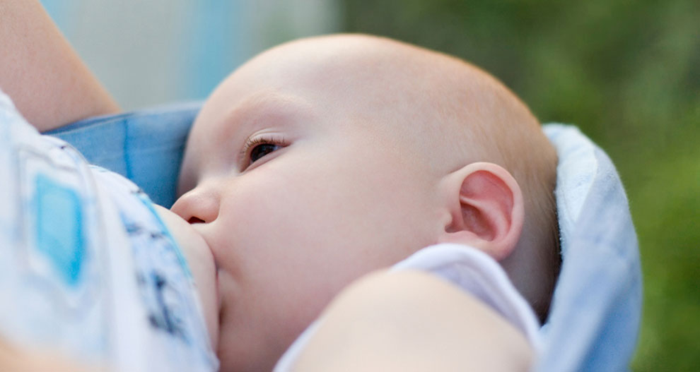 Gros plan sur le visage d'un bébé, partiellement caché par un tissu, avec un arrière-plan flou.