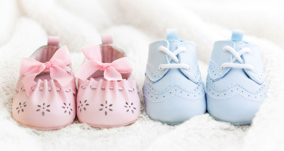 Deux paires de chaussures pour bébé, l'une rose avec des perforations florales et un nœud, l'autre bleue avec un design à lacets et des perforations décoratives.