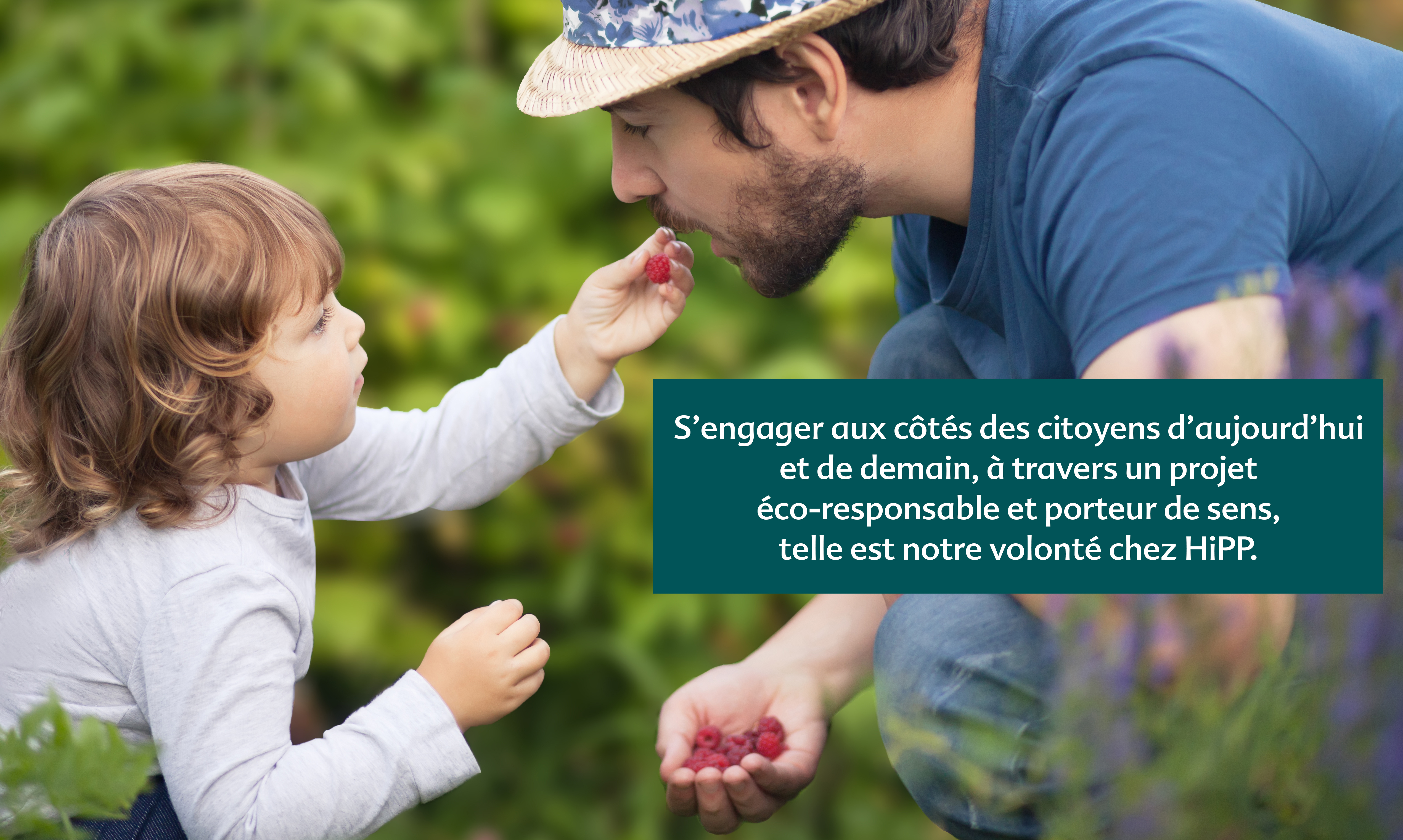 Un homme et un enfant partagent un moment dans un jardin, l'enfant donnant une framboise à l'homme.