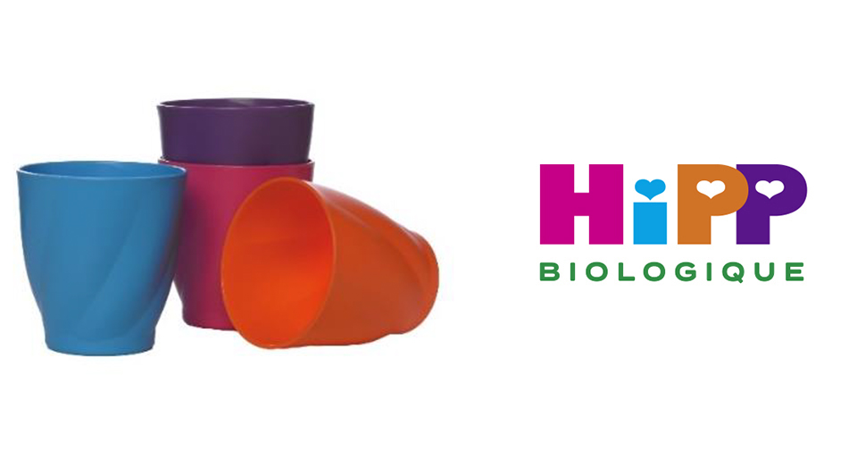 Une pile de trois gobelets de couleur bleue, violette et orange est placée à côté d'un logo indiquant "HIPP BIOLOGIQUE" en lettres colorées.