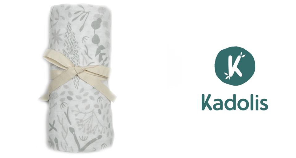 Un article enroulé avec un motif floral attaché avec un ruban beige est placé à côté d'un logo avec la lettre "K" à l'intérieur d'un cercle vert et le mot "Kadolis" en dessous.