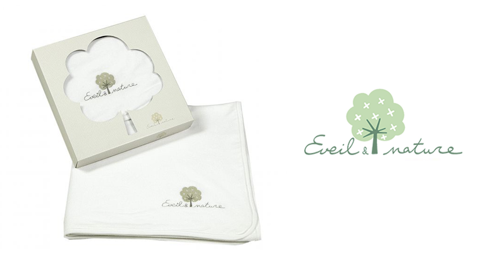 Un tissu blanc portant le logo d'un arbre et le texte "Eveil & nature" est placé à côté d'une boîte portant un logo d'arbre et un texte similaires.