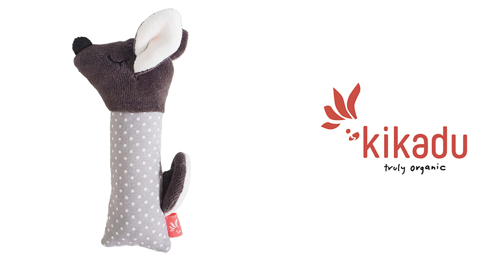 Une peluche ressemblant à une souris au corps gris pointillé et à la tête brune est présentée à côté d'un logo indiquant "kikadu truly organic".