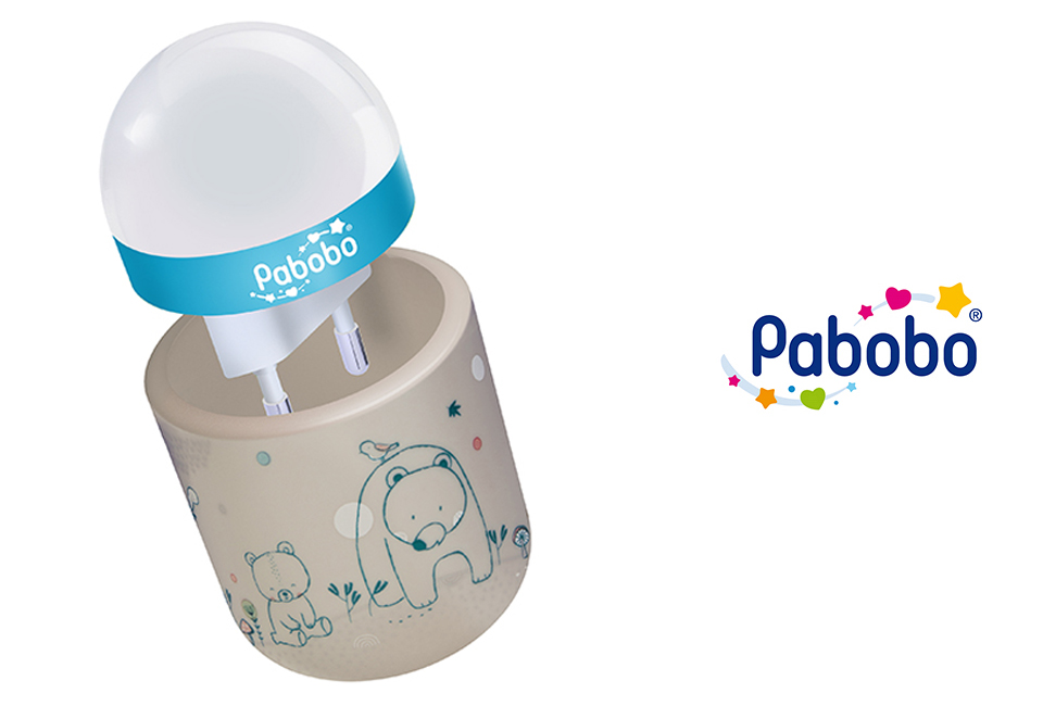Veilleuse Pabobo avec une base beige représentant un ours et un autre plus petit, et un sommet en forme de dôme blanc avec une bande bleue.