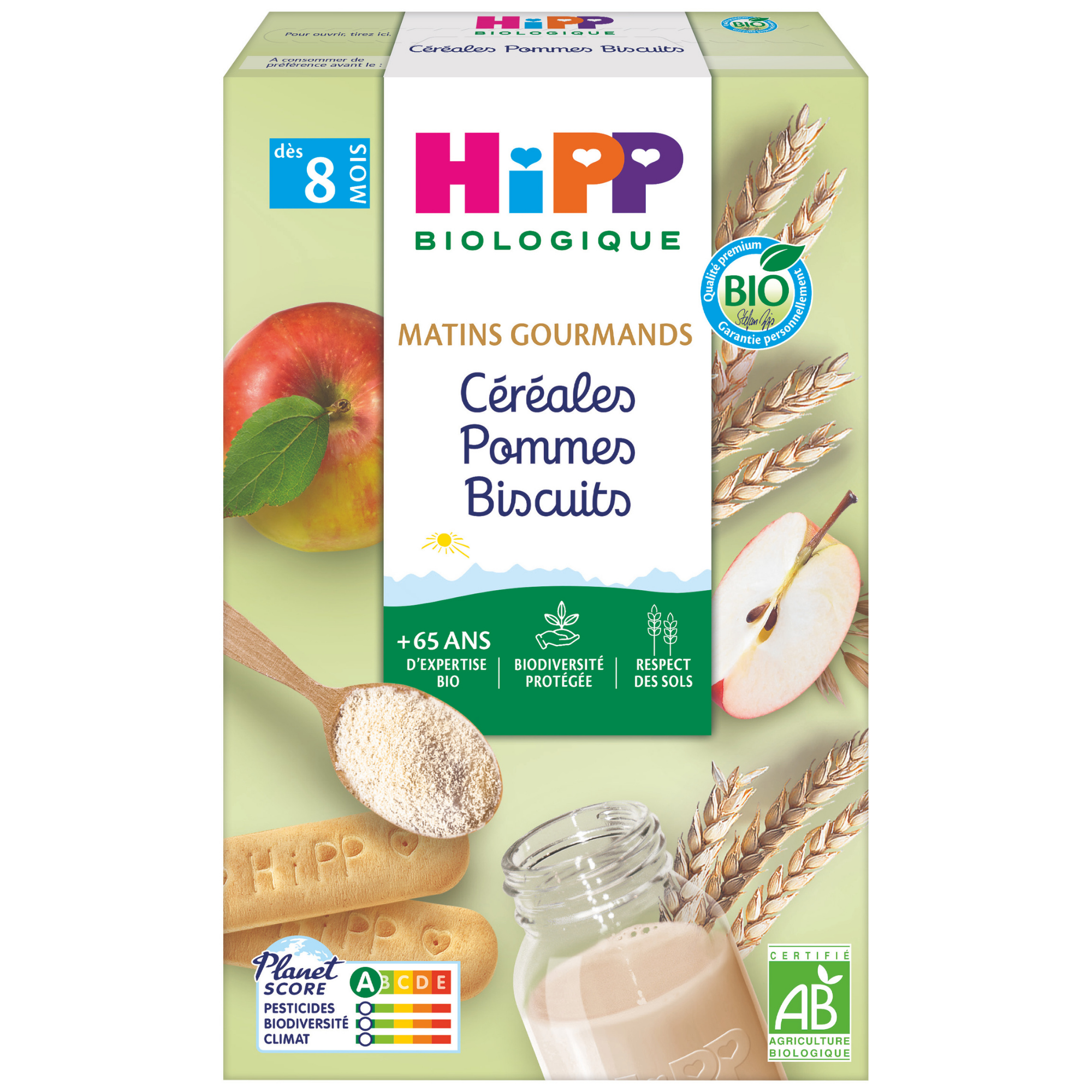 Une boîte de produits alimentaires biologiques pour bébés, comprenant une cuillère de poudre, un pot de liquide et un biscuit, avec une étiquette Planet Score et une marque de certification.